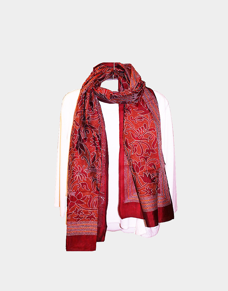 Try out this bright maroon silk scarf with reverse kantha embroidery work. This lightweight scarf has orange & white thread with patterns of lotus & leaves.