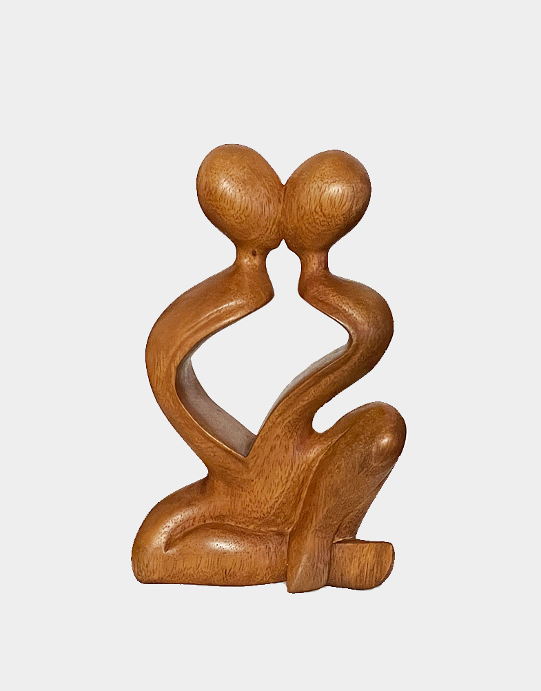 Seated face to face, a couple kisses, their sinuous bodies suggest one shared heart. Artist Made Wirata presents the force of the lovers' passion in suar wood. Free shipping.