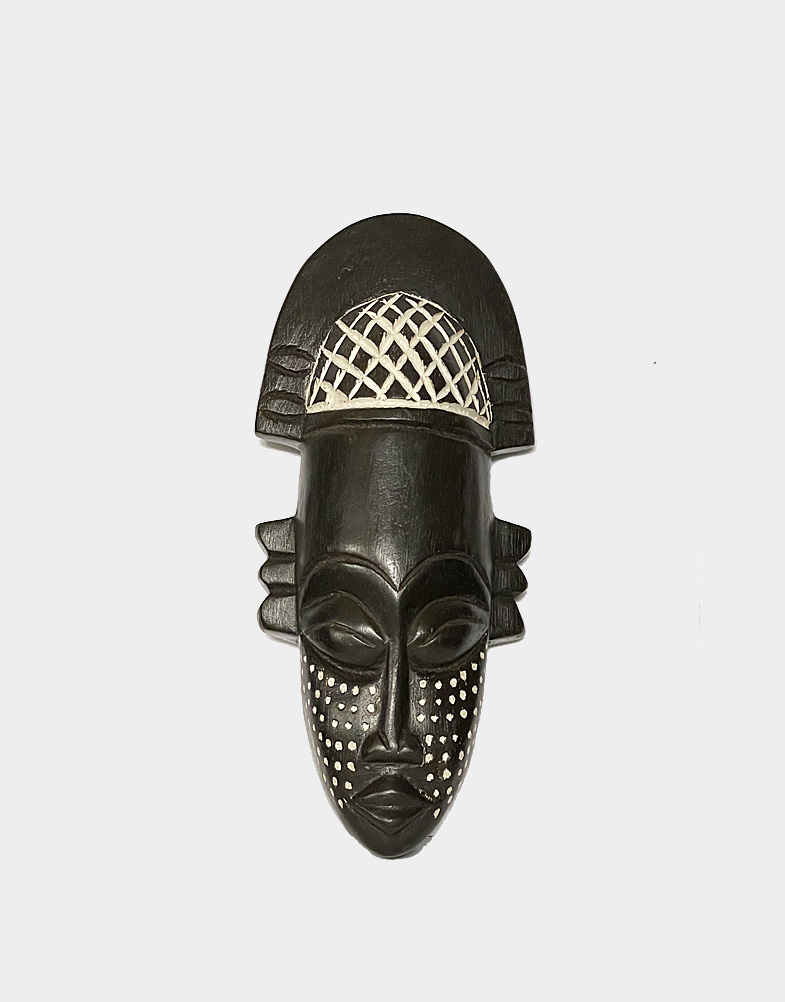 Victor Dushie in Ghana, Africa created this small wooden black mask from sese wood, giving it a dark finish and incising it on the cheeks and headdress.