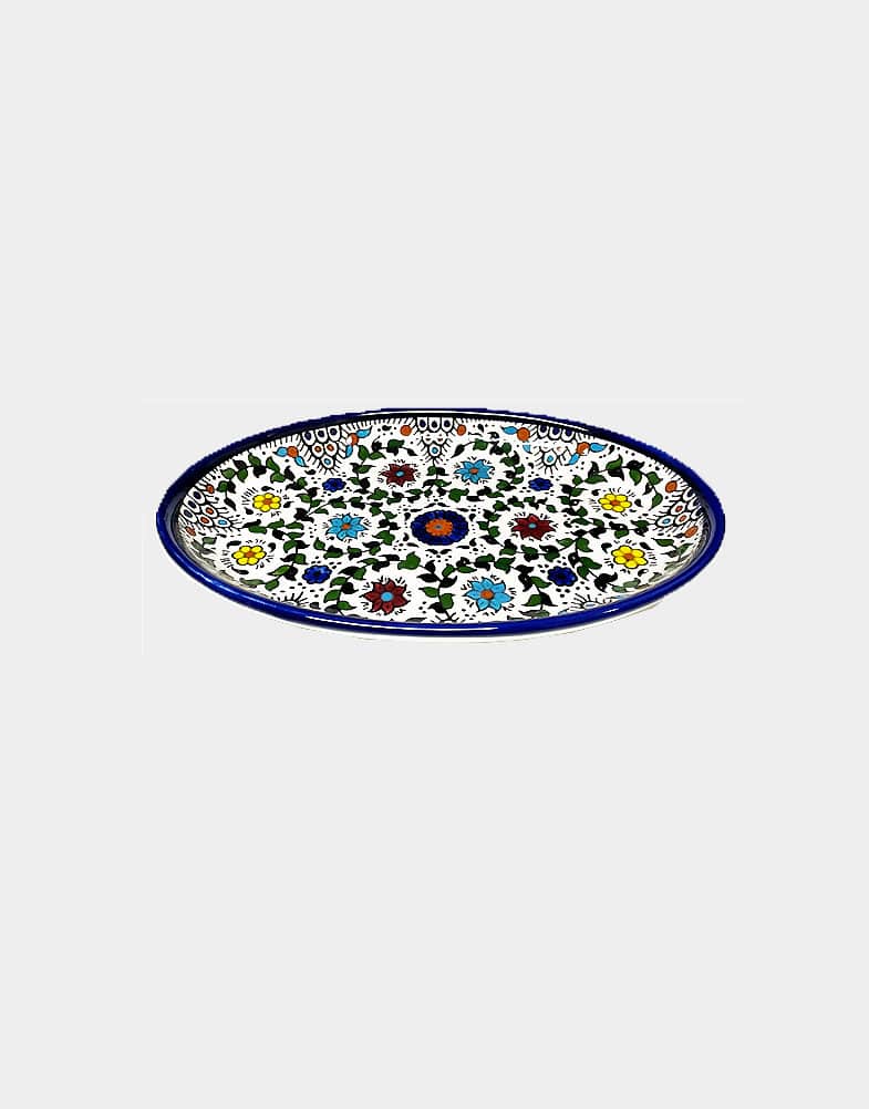 Colorful tabletop ceramic oval tray is intricately hand painted in bold floral designs, a traditional Palestinian craft. Microwave safe. Not oven safe. Buy now